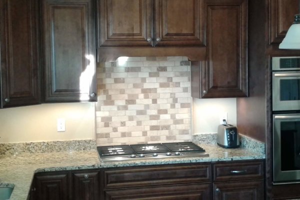 Kitchen with brown cabinets, granite counter tops, and Range-Hood-Cabinet-Style.