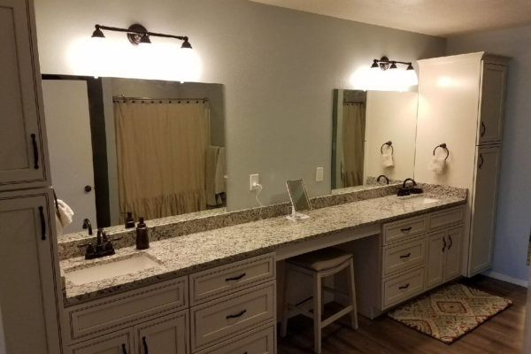 A modern bathroom with two sinks and a vanity, featuring sleek design and ample storage space.