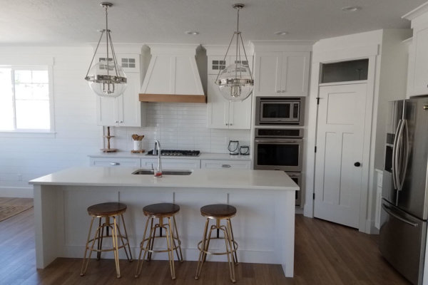 A contemporary kitchen featuring white cabinets and stainless steel appliances.