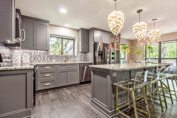 A stylish kitchen with gray cabinets and stainless steel appliances.