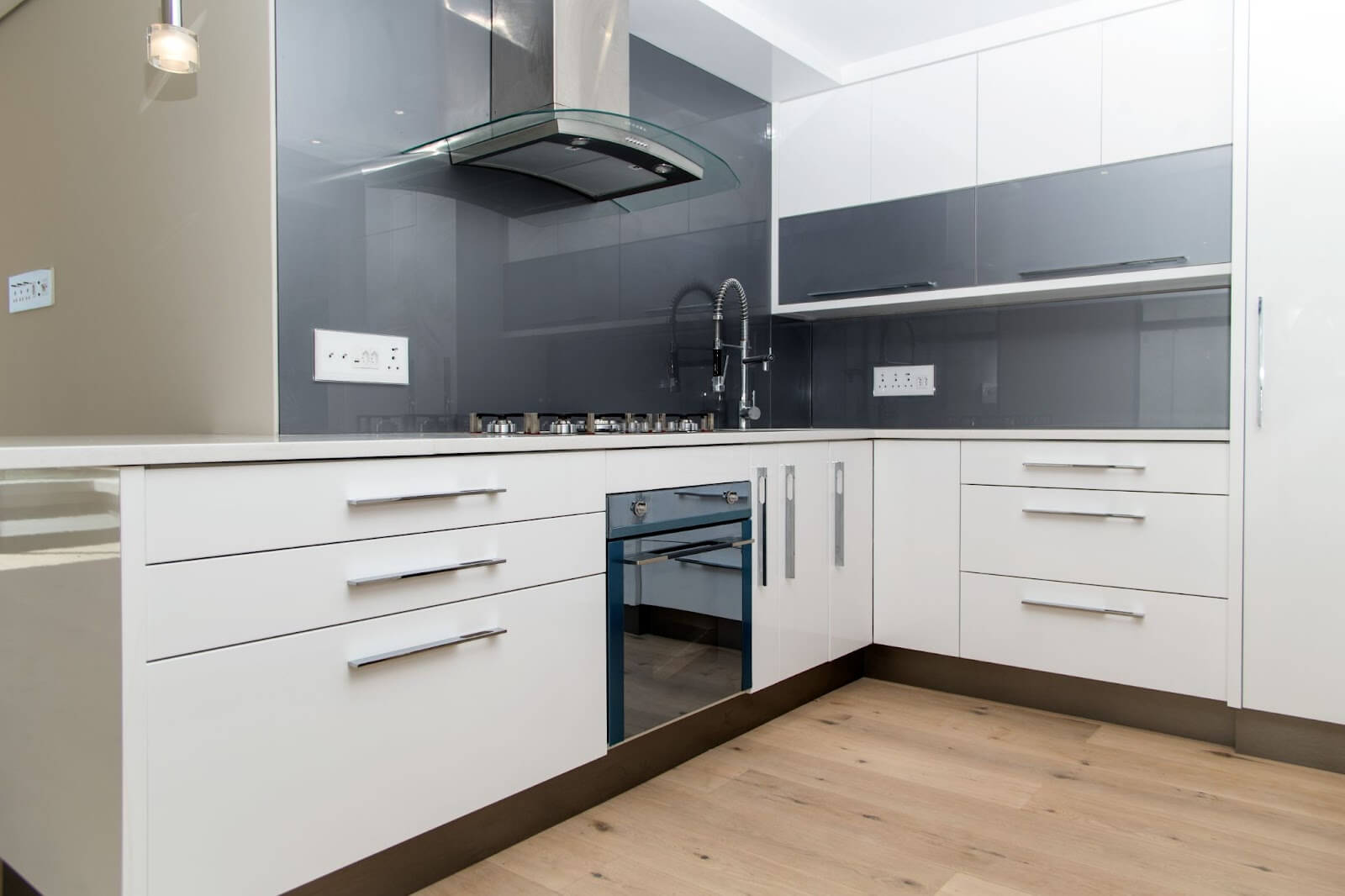 Custom cabinet design featuring white cabinets and stainless steel oven in kitchen.