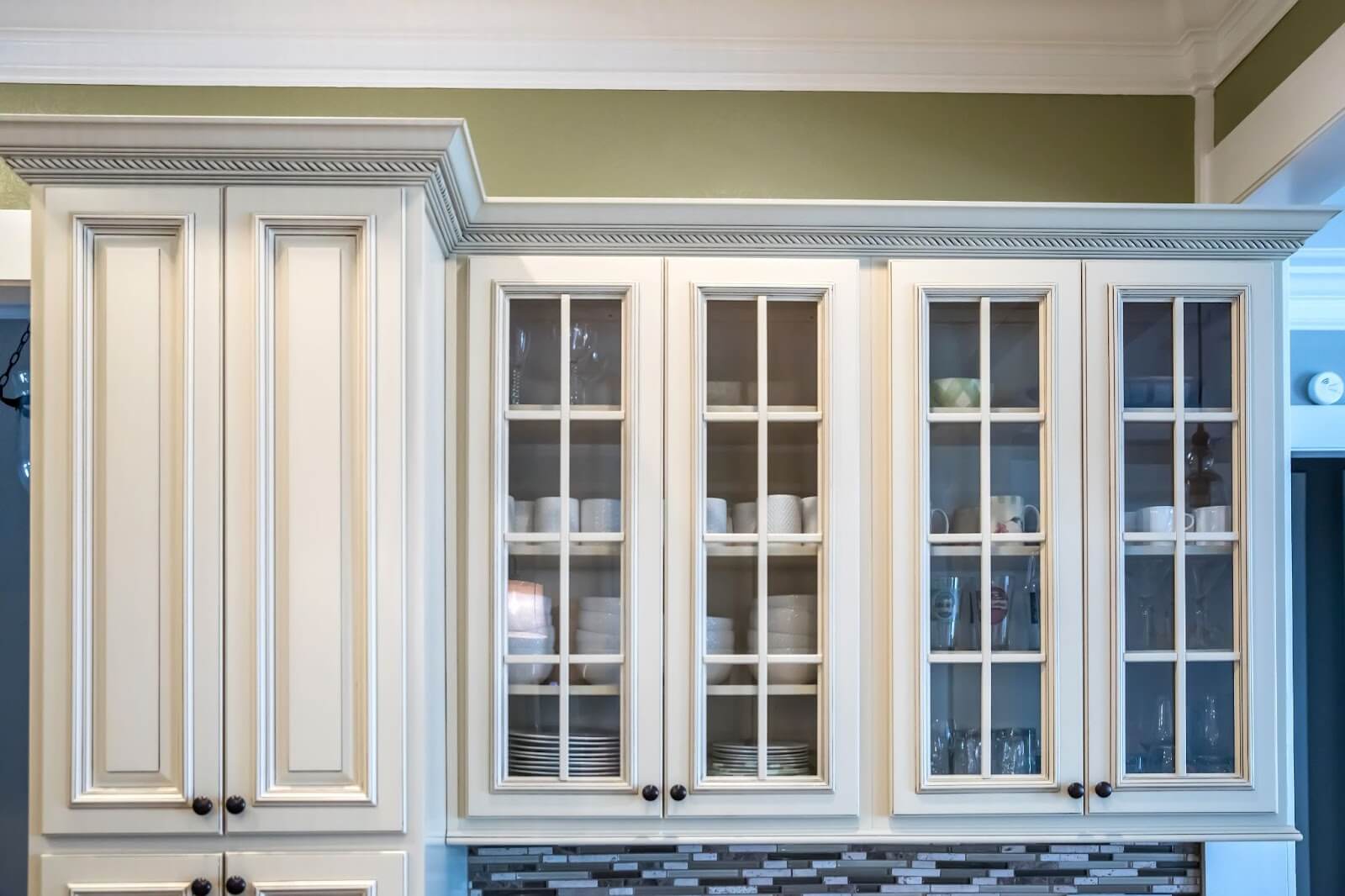 A stylish kitchen with custom white cabinets and a polished countertop, emphasizing a contemporary and organized space.